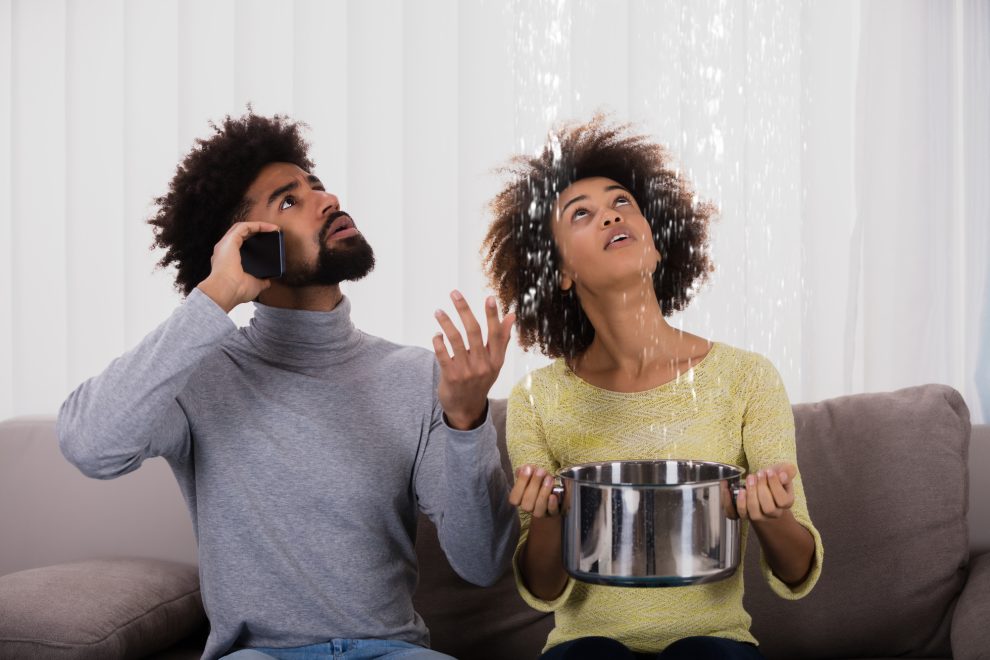woman using utensil for collecting water leaking from ceiling